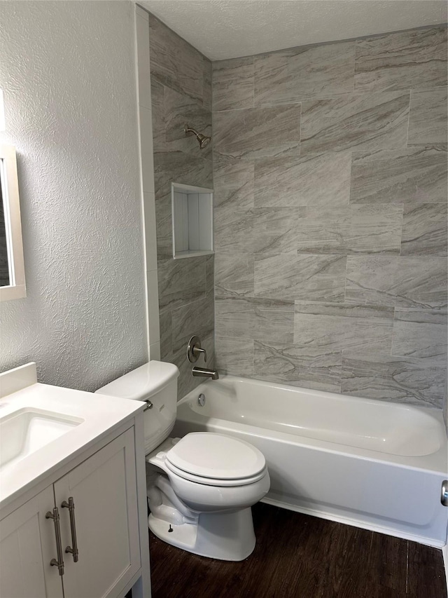 full bathroom with toilet, tiled shower / bath, hardwood / wood-style flooring, and vanity