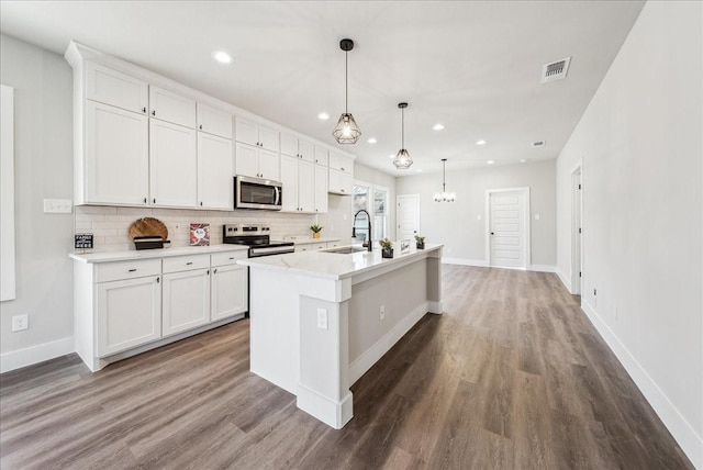 kitchen featuring pendant lighting, sink, white cabinetry, an island with sink, and stainless steel appliances