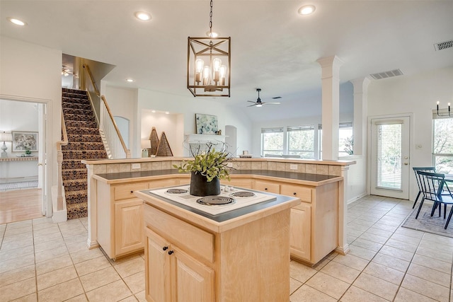 kitchen with white electric stovetop, light brown cabinets, visible vents, and a center island