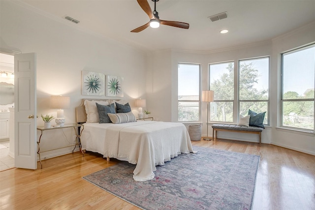 bedroom featuring ceiling fan, ensuite bathroom, and light hardwood / wood-style flooring