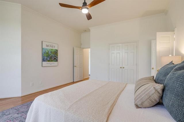 bedroom with ceiling fan, a closet, hardwood / wood-style floors, and crown molding