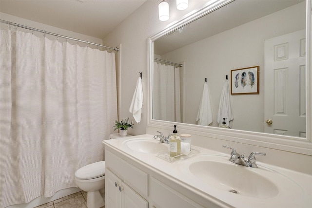 full bathroom featuring toilet, tile patterned flooring, double vanity, and a sink