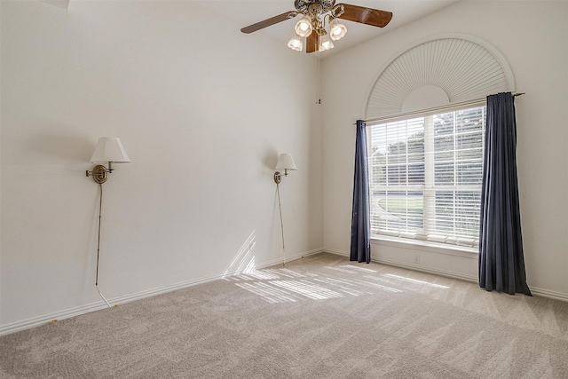 unfurnished room featuring light colored carpet, ceiling fan, and baseboards