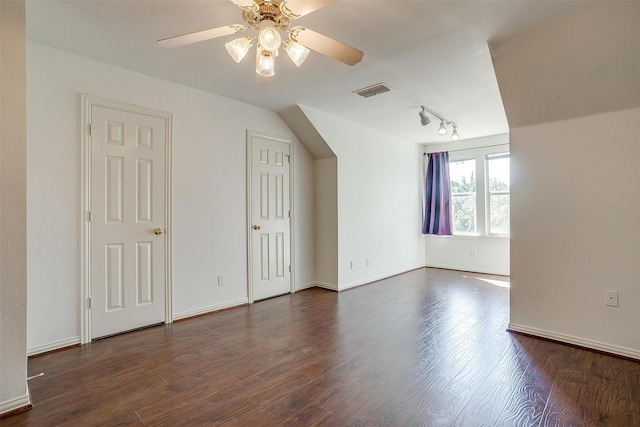 additional living space featuring dark wood-style floors, ceiling fan, visible vents, and baseboards