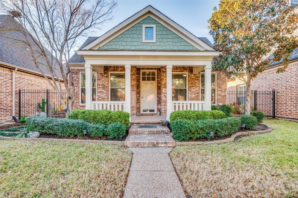 view of front of home with covered porch and a front yard