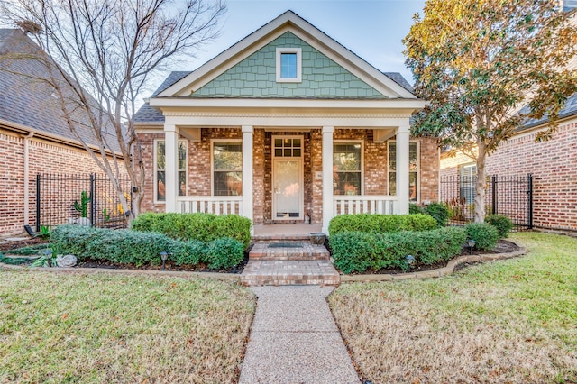 view of front of home with covered porch and a front yard