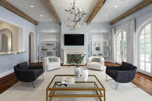 living room featuring beam ceiling, built in shelves, french doors, and light hardwood / wood-style flooring