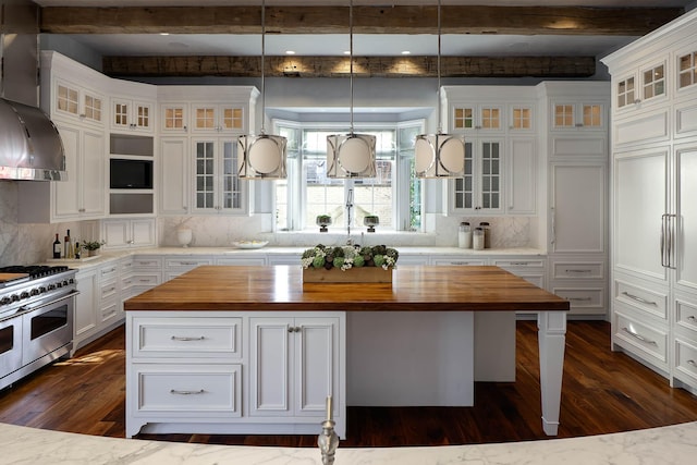 kitchen with double oven range, backsplash, a center island, and wooden counters