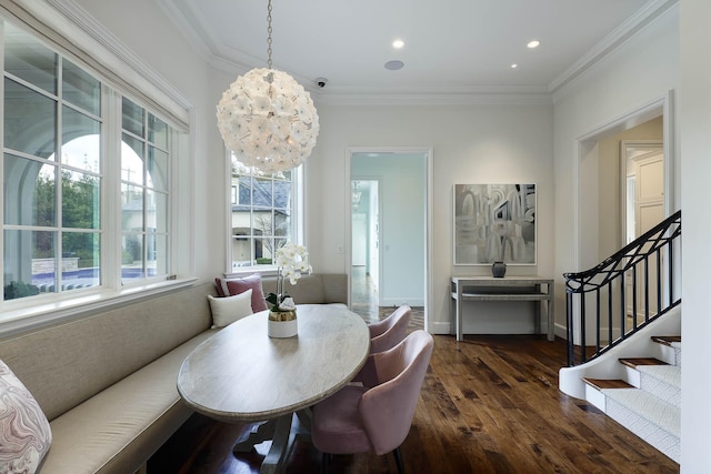 dining area with crown molding, dark hardwood / wood-style flooring, and an inviting chandelier