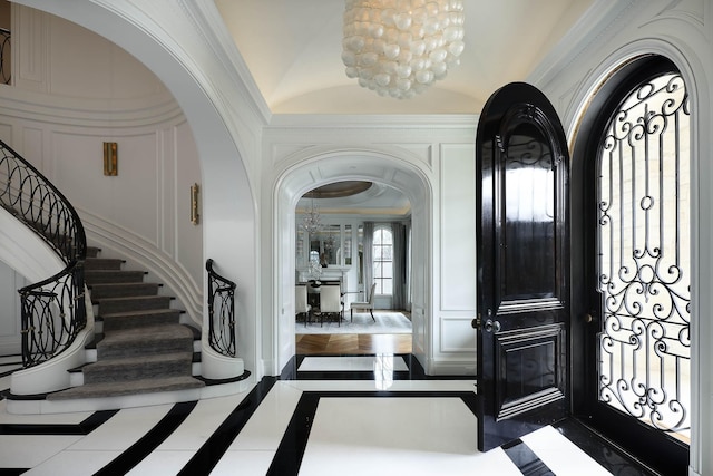 foyer featuring crown molding and a chandelier