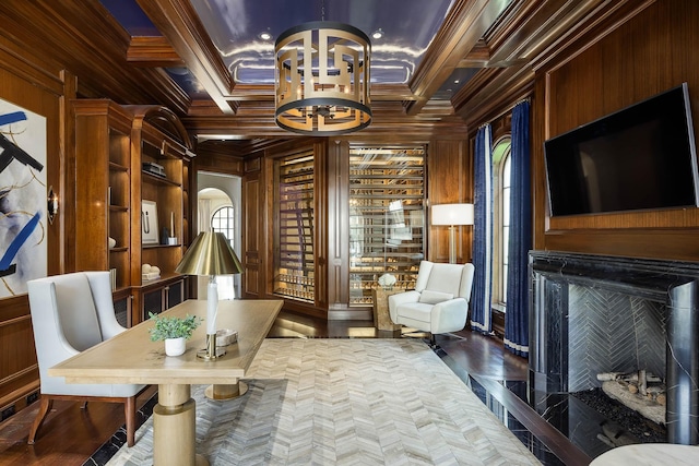 living area featuring beam ceiling, ornamental molding, an inviting chandelier, and wooden walls