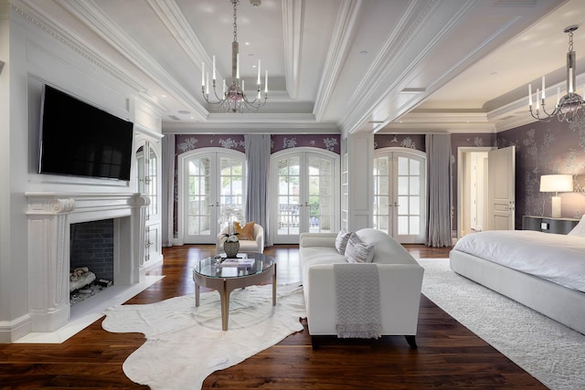 bedroom with access to exterior, a raised ceiling, dark wood-type flooring, french doors, and a chandelier