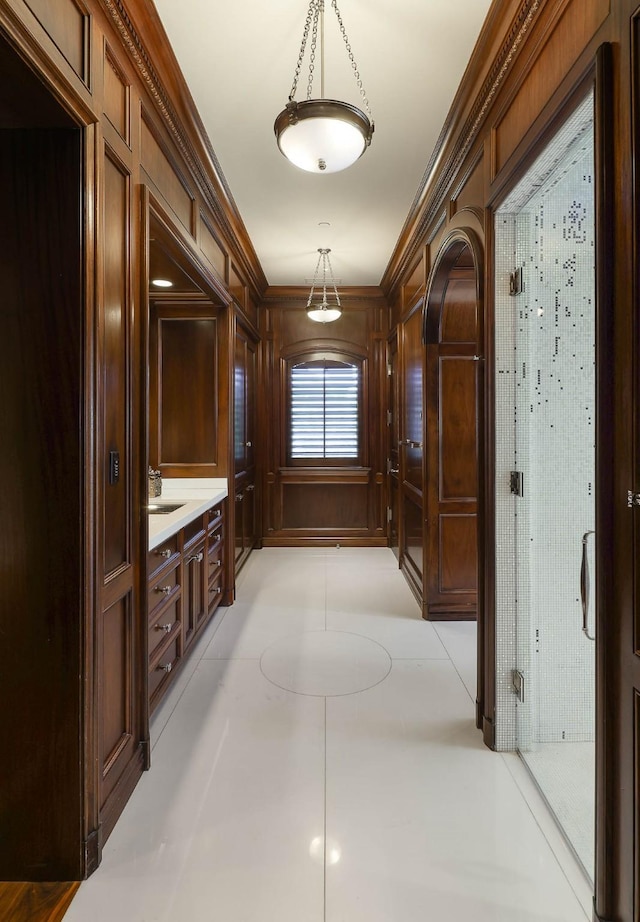 hall with crown molding and wooden walls