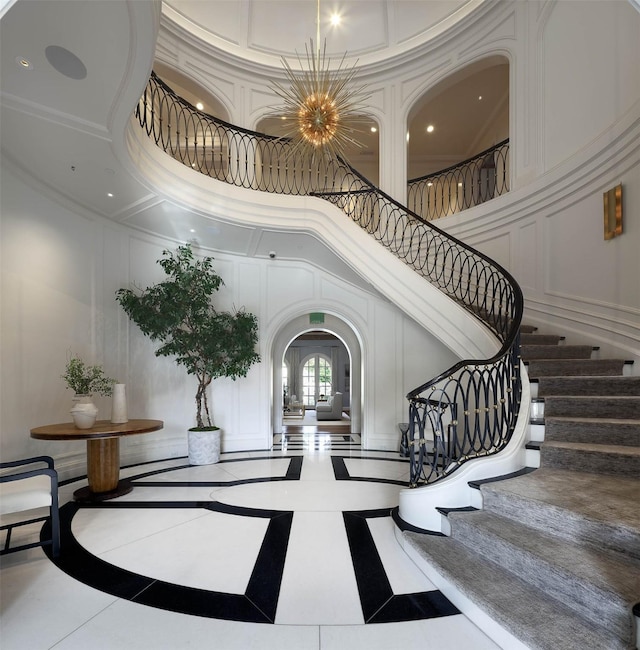 tiled foyer featuring a high ceiling and an inviting chandelier