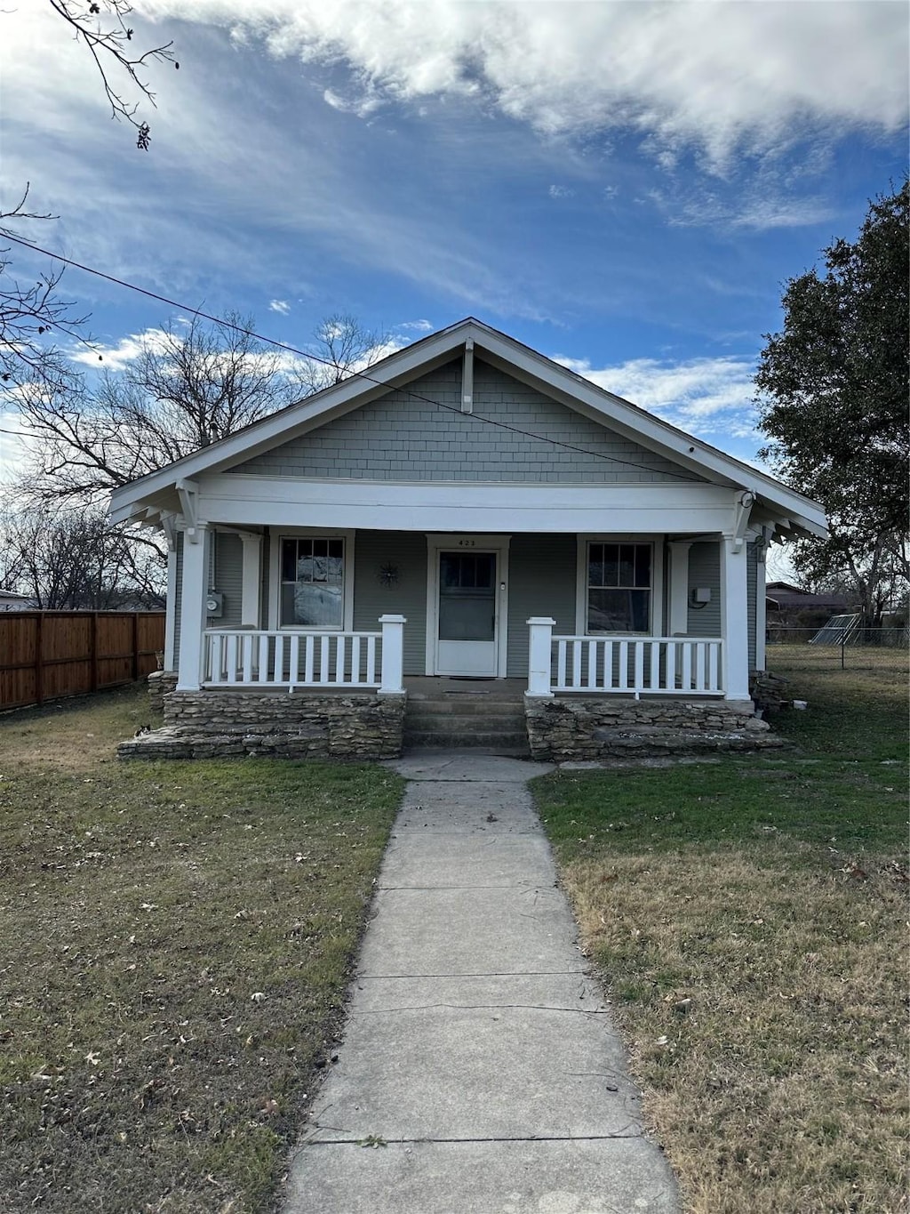 view of front of property with covered porch and a front lawn