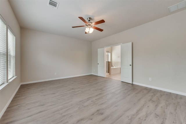 empty room with ceiling fan and light hardwood / wood-style flooring