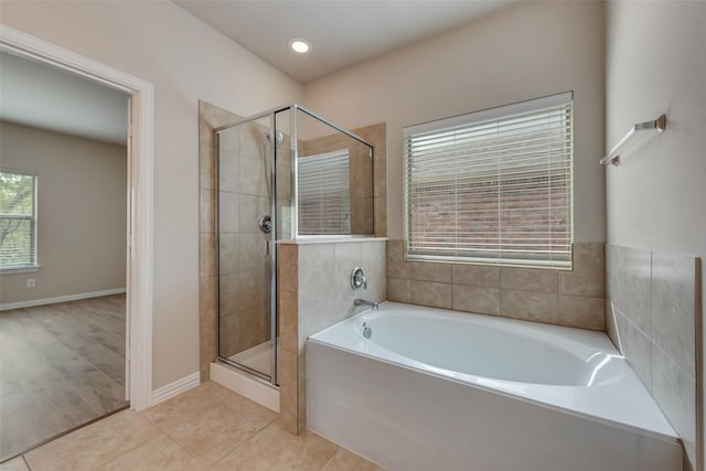 bathroom with tile patterned flooring and shower with separate bathtub