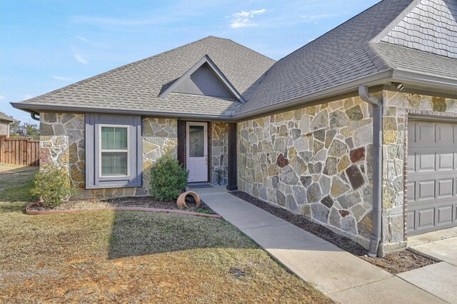 view of front facade featuring a front yard, a garage, and central air condition unit