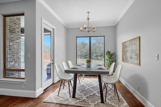 dining area with ornamental molding, plenty of natural light, wood finished floors, and baseboards