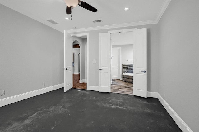 unfurnished bedroom with finished concrete floors, arched walkways, visible vents, and baseboards