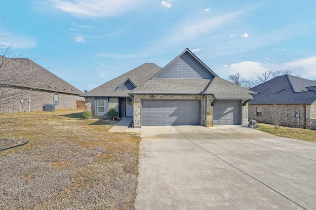 view of front of home with a garage, driveway, stone siding, roof with shingles, and a front yard