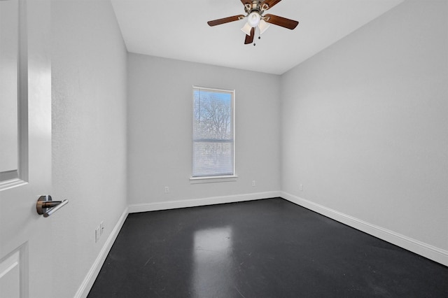 unfurnished room featuring finished concrete flooring, ceiling fan, and baseboards