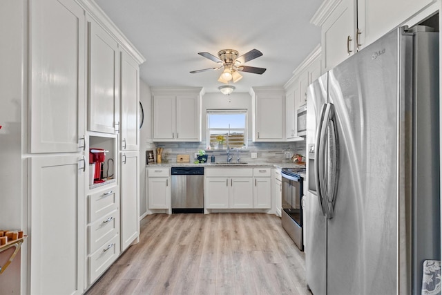 kitchen with white cabinetry, ceiling fan, appliances with stainless steel finishes, tasteful backsplash, and light hardwood / wood-style flooring