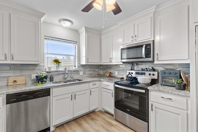 kitchen featuring stainless steel appliances, backsplash, white cabinetry, and sink