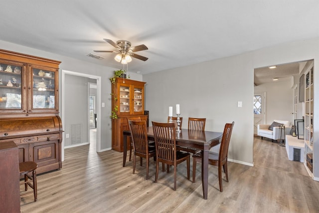 dining area with light wood-type flooring and ceiling fan