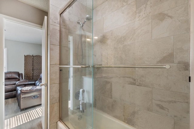 bathroom featuring combined bath / shower with glass door