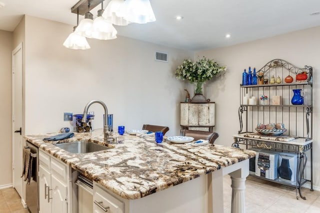 kitchen with a kitchen breakfast bar, white cabinets, light stone countertops, and sink