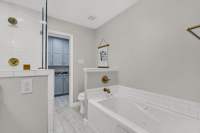 bathroom with toilet, a bathtub, and wood-type flooring