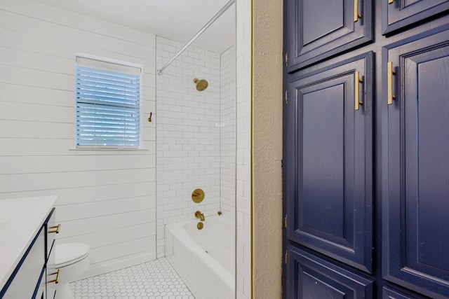 full bathroom with tile patterned floors, tiled shower / bath combo, vanity, and toilet