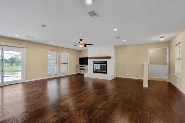 unfurnished living room featuring dark wood-type flooring, a fireplace, and ceiling fan