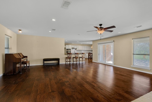 living room with ceiling fan and dark hardwood / wood-style floors