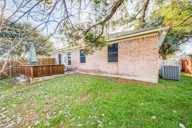 back of property with central AC and a yard