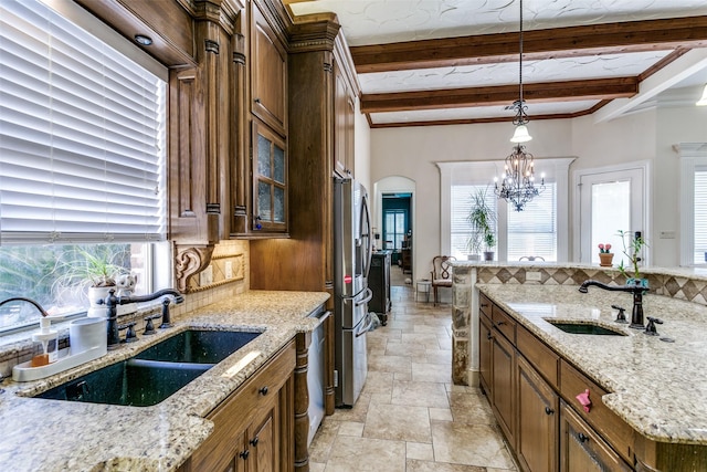 kitchen with light stone countertops, beamed ceiling, sink, backsplash, and a notable chandelier