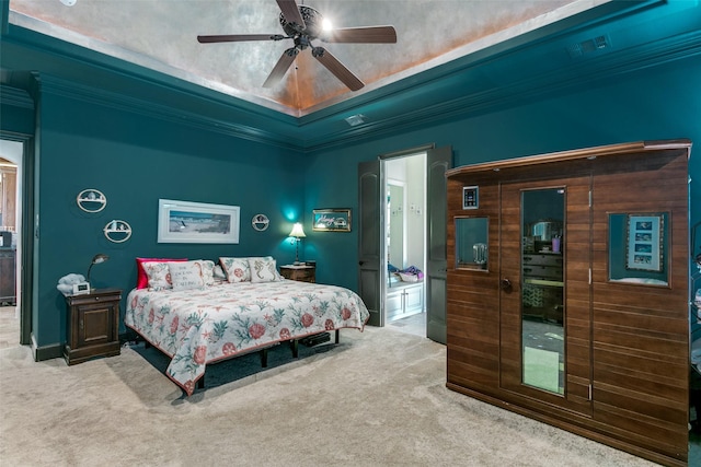 bedroom with ceiling fan, light colored carpet, a tray ceiling, and crown molding