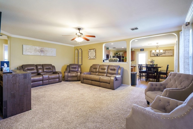 carpeted living room featuring ceiling fan with notable chandelier and crown molding