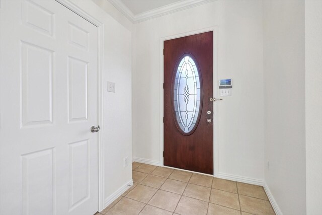 tiled entrance foyer featuring crown molding