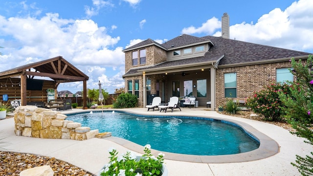 view of swimming pool with ceiling fan, a gazebo, a patio area, and french doors