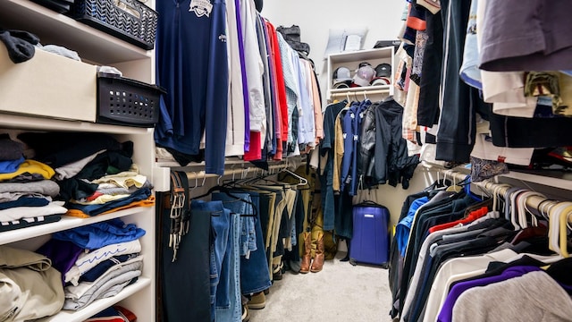 walk in closet featuring light colored carpet