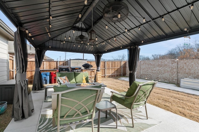 view of patio with ceiling fan, a gazebo, and an outdoor fire pit