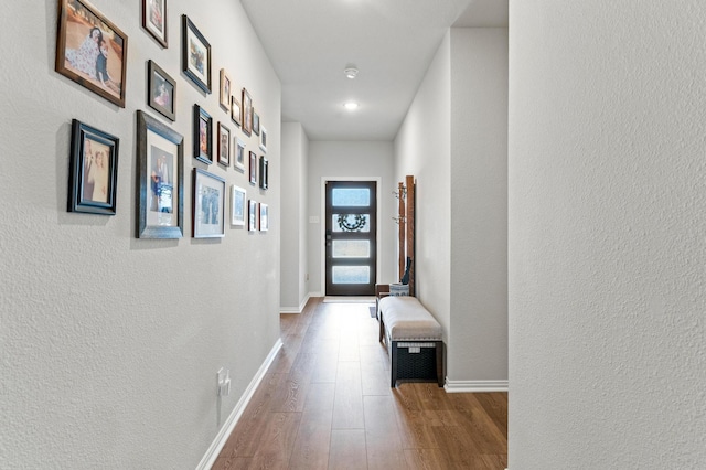 corridor with hardwood / wood-style flooring