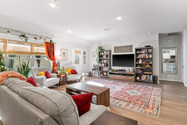 living room with light wood-type flooring and vaulted ceiling