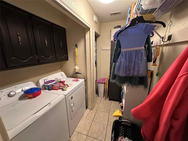 washroom with washer and clothes dryer, light tile patterned floors, and a textured ceiling