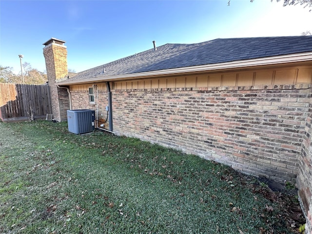 view of side of home featuring a yard and central AC unit