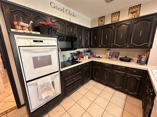 kitchen with black appliances, light tile patterned floors, and ornamental molding