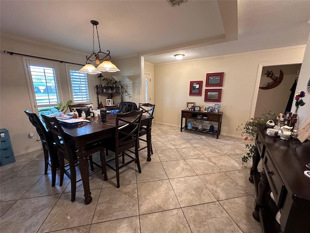 dining space featuring a raised ceiling, crown molding, and tile patterned flooring