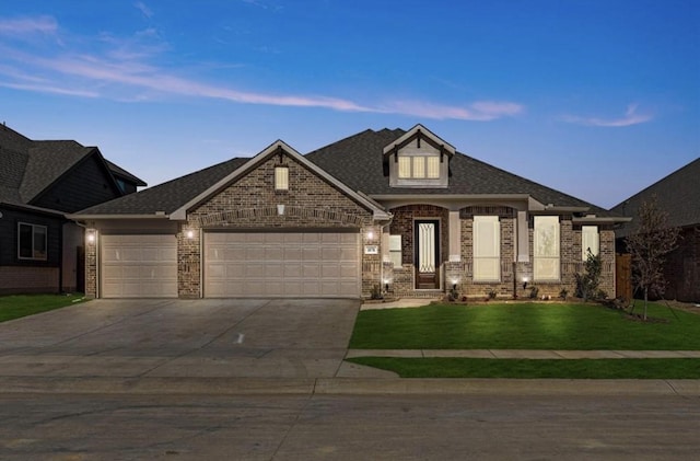 view of front of house featuring concrete driveway, a front lawn, an attached garage, and brick siding